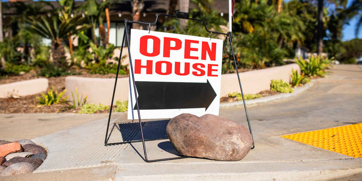 Rock placed on open house sign